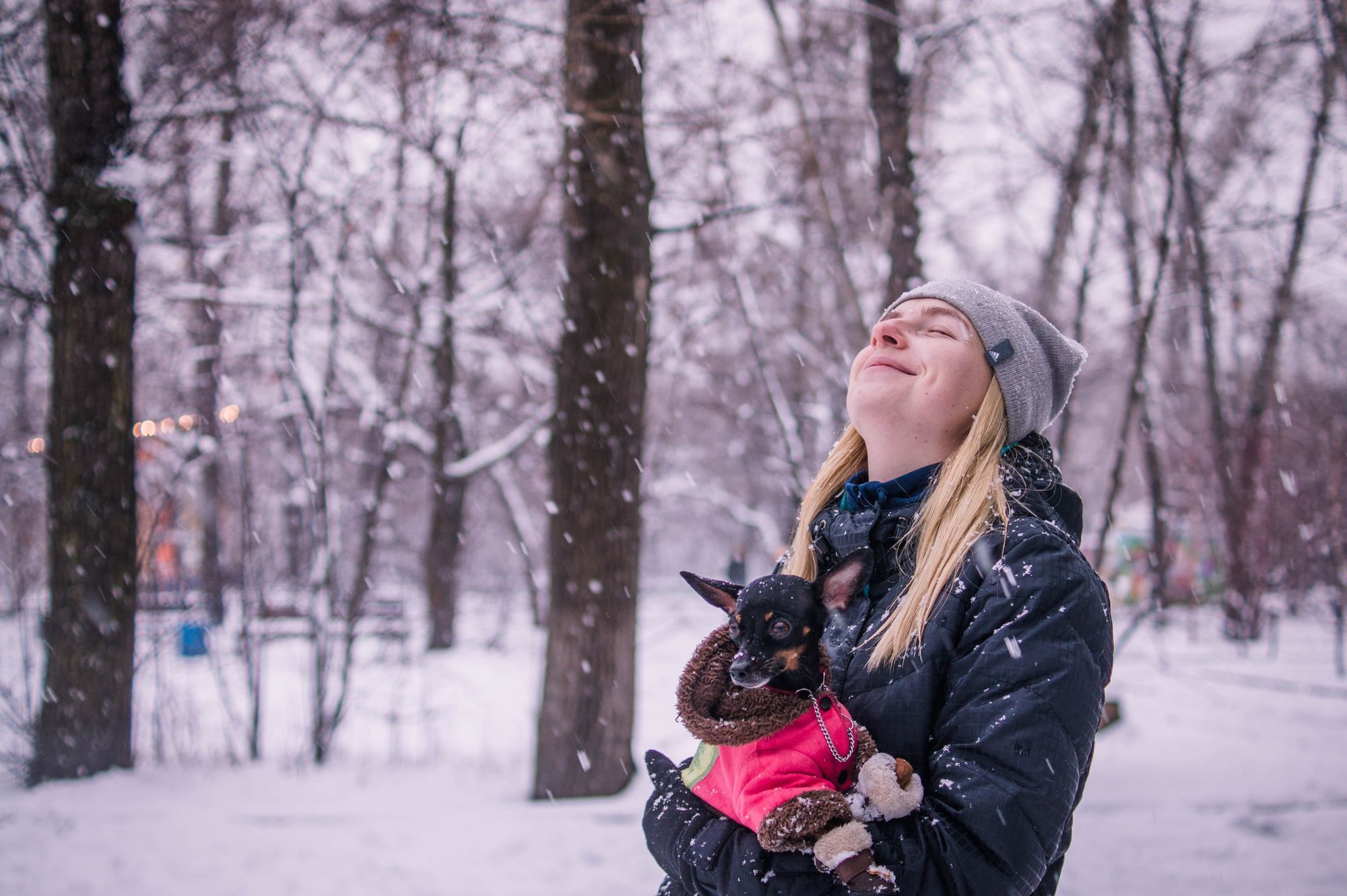Turgåer i varm dunjakke i en snødekt skog