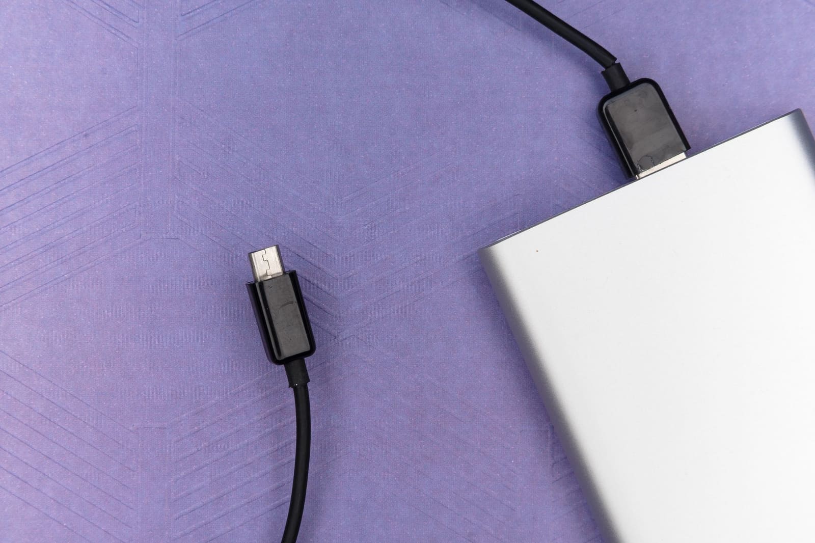 Powerbank med USB-C-kabel på lilla bakgrunn