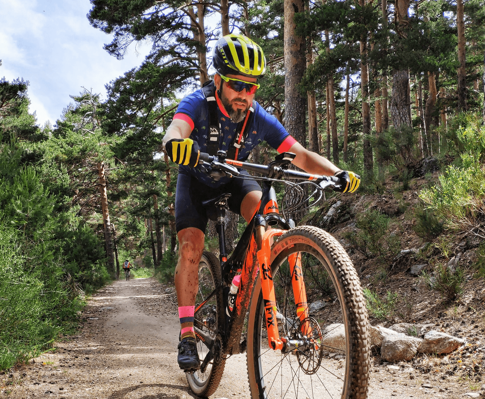 Syklist med sportsbriller og hjelm på terrengsykkel i skogen