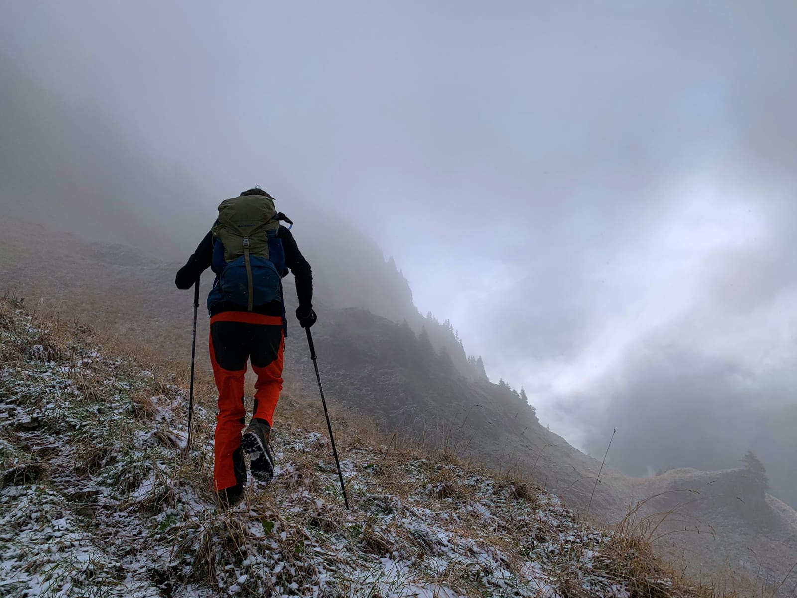 Fjellvandrer med gåstaver i tåke