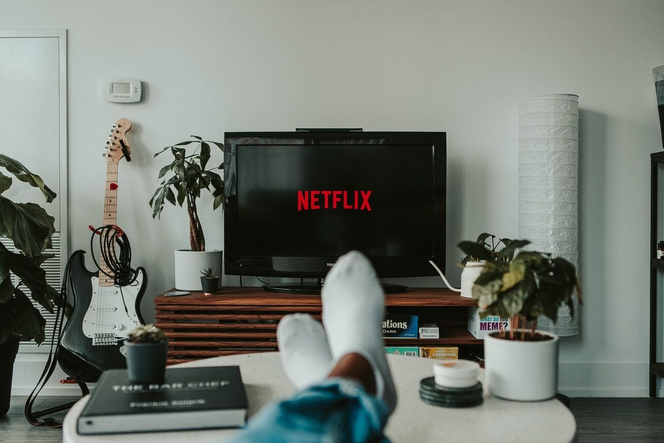 Føtter på bordet foran en TV som viser Netflix
