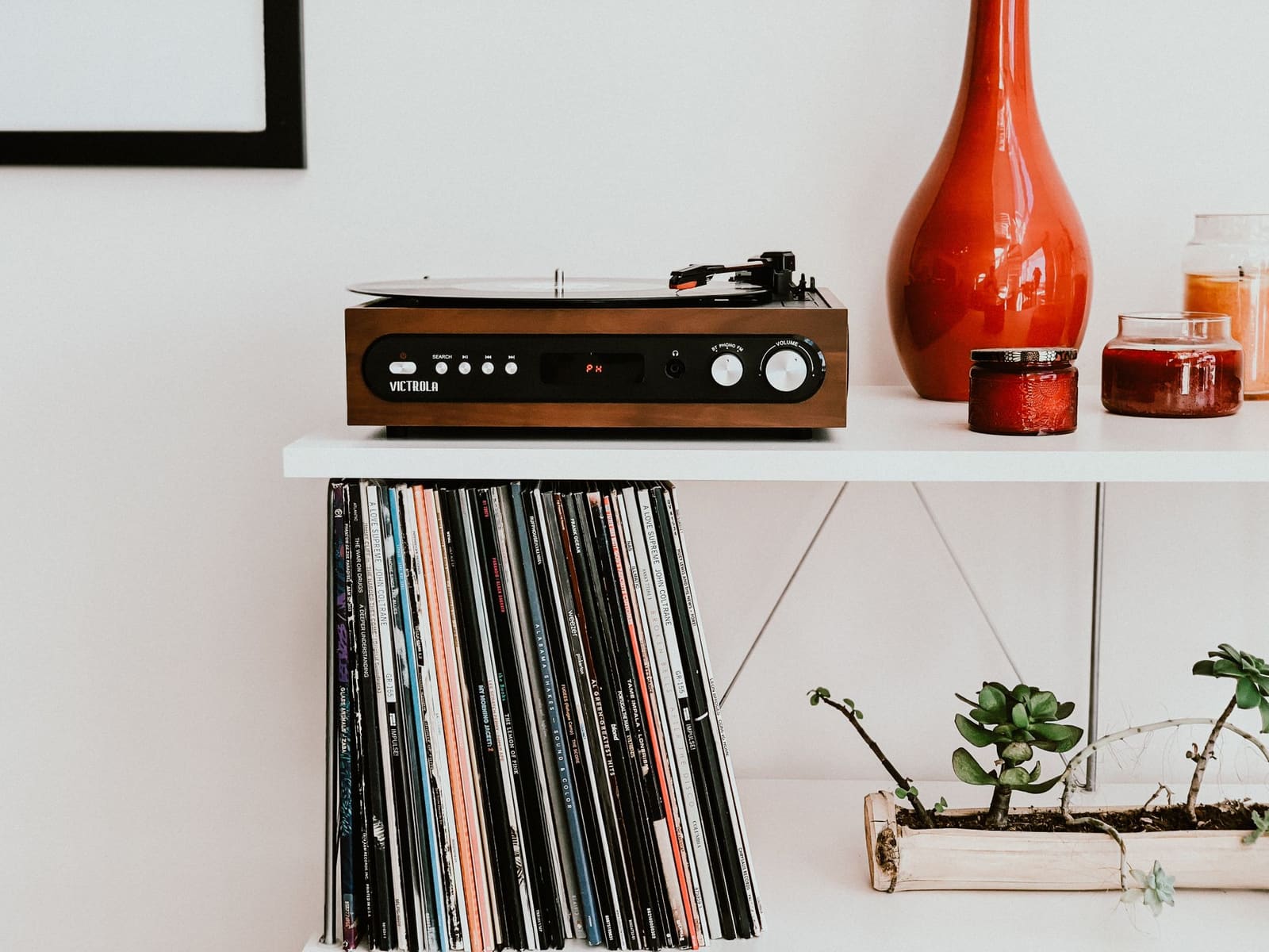 Platespiller på en hylle over en samling vinylplater
